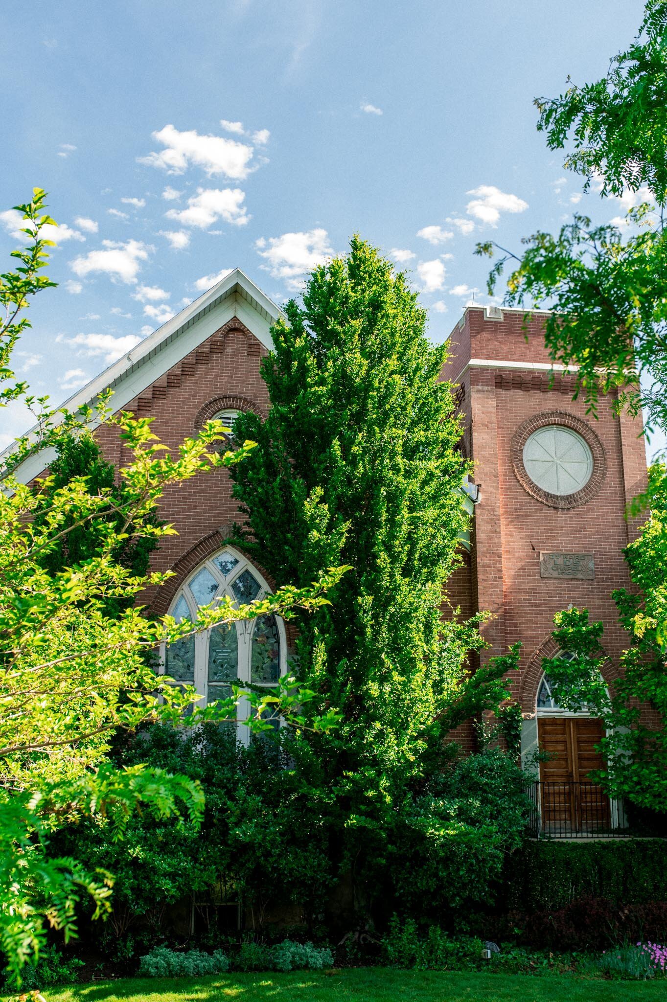 The Northampton House - Historic brick building with arched windows and lush greenery in American Fork